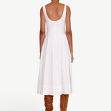 Back view of KABE SHOP INC Wells white midi dress with a scoop back and flared skirt paired with brown suede boots.