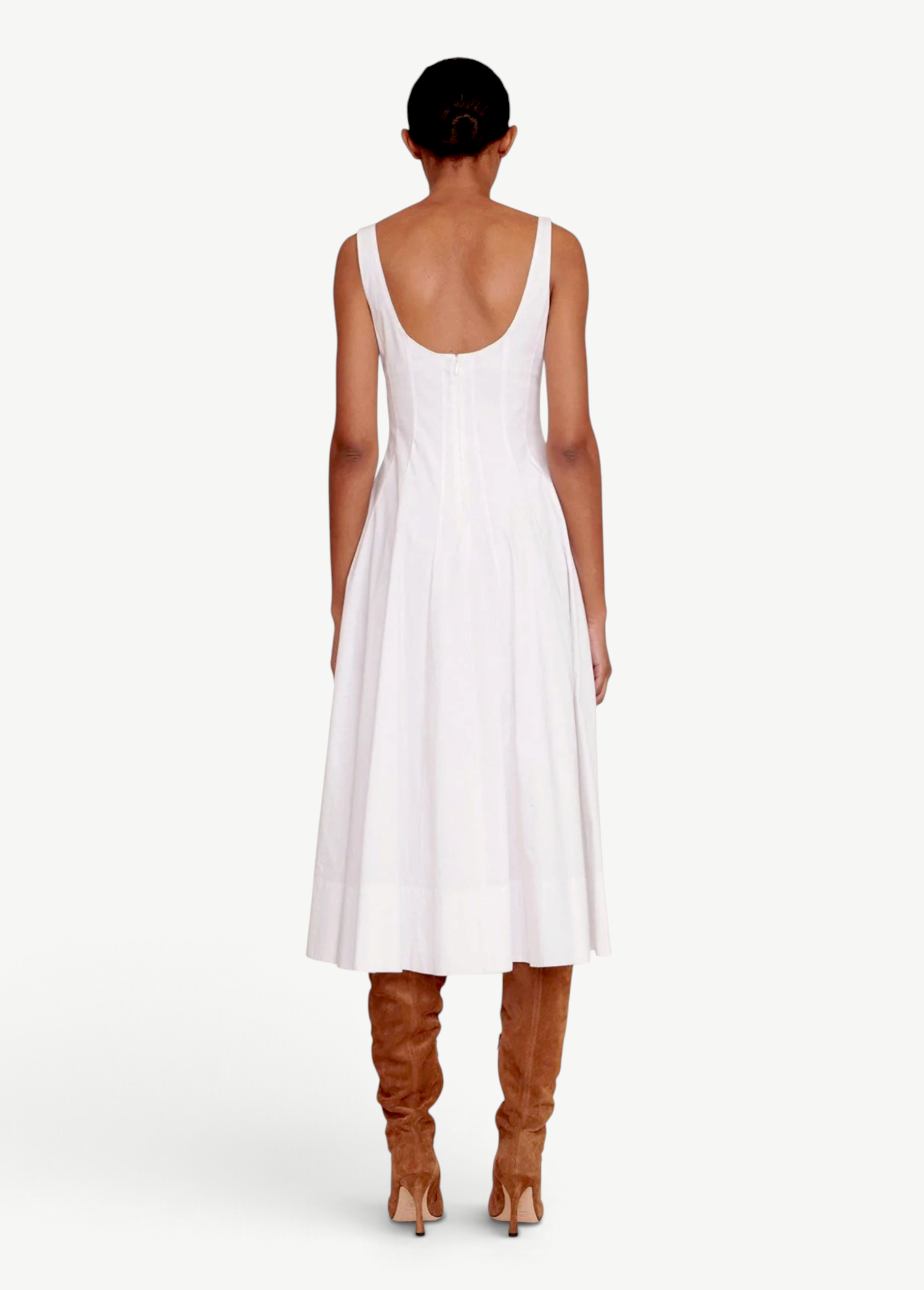 Back view of KABE SHOP INC Wells white midi dress with a scoop back and flared skirt paired with brown suede boots.