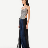 Model wearing KABE SHOP INC Zaya top with silver sequin bodice, open back, and long black tulle tie detail.
