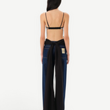 Model wearing KABE SHOP INC Zaya top with open back, adjustable straps, and long flowing black tulle tie detail.