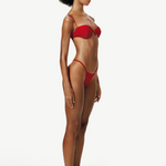 Model wearing a KABE SHOP INC red balconette bikini top with delicate straps and underwire, side profile view.