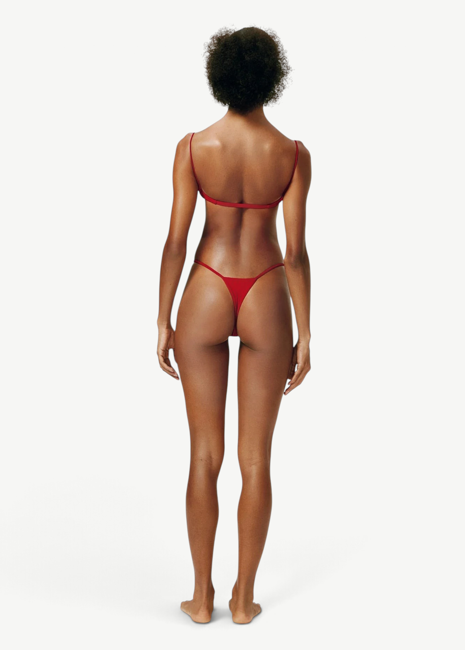 Model wearing a KABE SHOP INC red bikini set with thin straps and a minimalist thong bottom, back view.