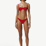 Model wearing KABE SHOP INC Classic Bottom in red, featuring a flattering medium-stretch recycled fabric design.