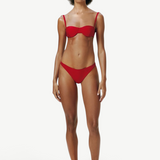 Model wearing KABE SHOP INC Classic Bottom in red, featuring a flattering medium-stretch recycled fabric design.