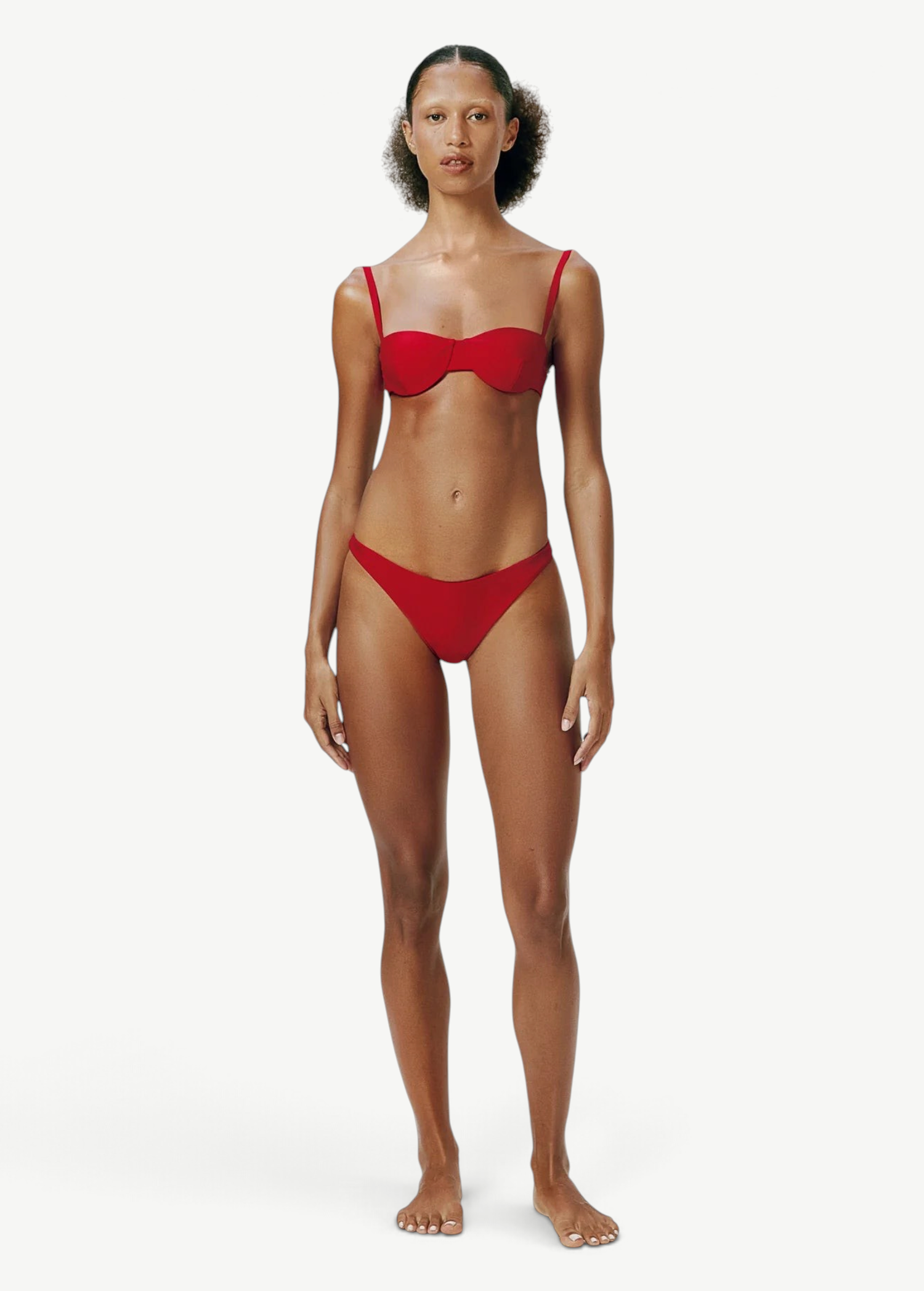 Model wearing KABE SHOP INC Classic Bottom in red, featuring a flattering medium-stretch recycled fabric design.