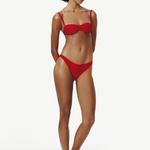 Model wearing KABE SHOP INC Classic Bottom in red, a recycled medium-stretch bikini bottom with a flattering fit.