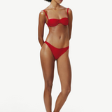 Model wearing KABE SHOP INC Classic Bottom in red, a recycled medium-stretch bikini bottom with a flattering fit.