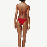 Model wearing KABE SHOP INC Classic Bottom in red, featuring a flattering medium-stretch recycled fabric design.