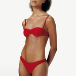 Model wearing KABE SHOP INC Classic Bottom in red, a recycled material bikini bottom with a flattering fit.