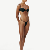 Model wearing a KABE SHOP INC black balconette bikini top with thin straps and U-shaped underwire, full body view.