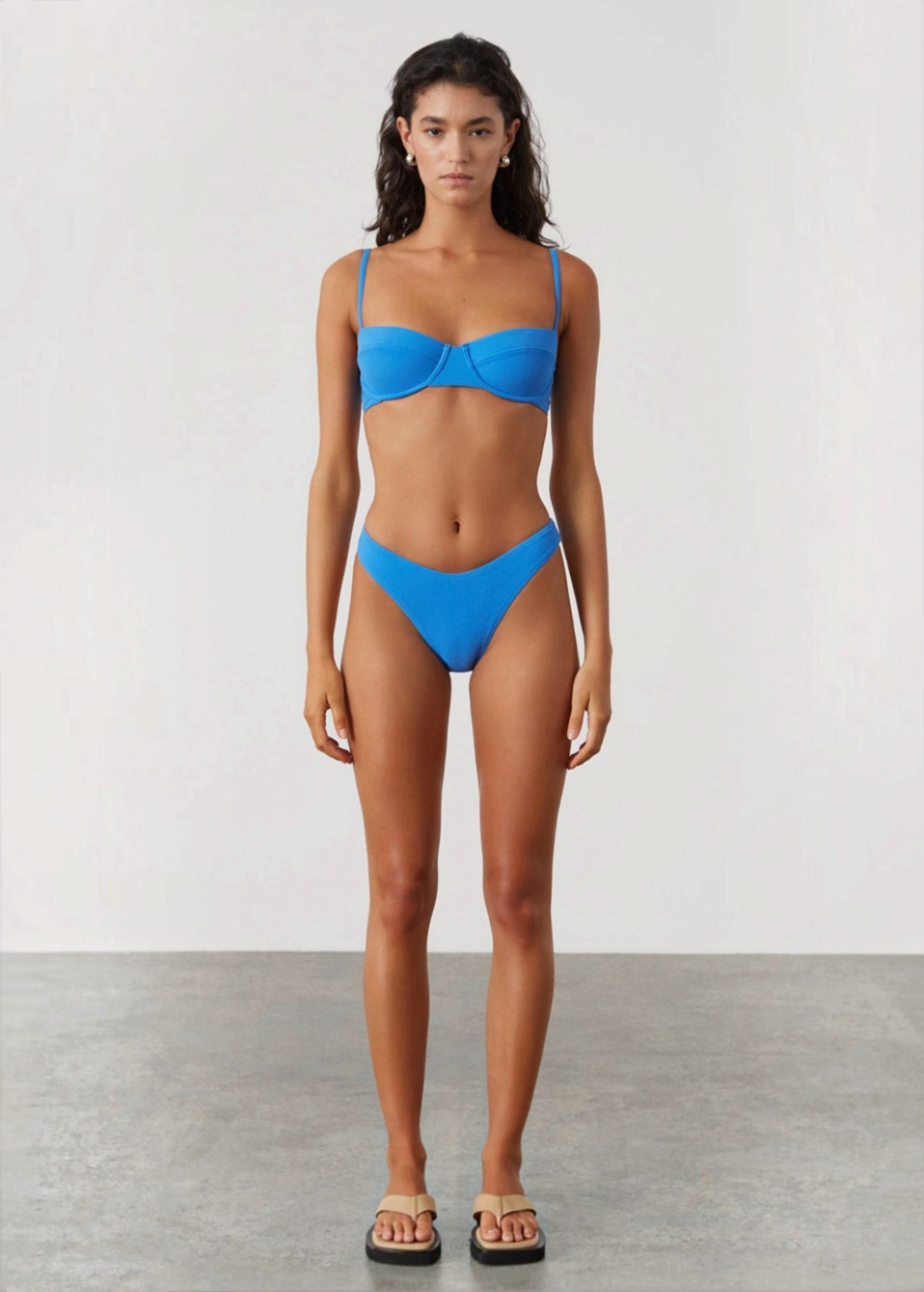 Model wearing KABE SHOP INC ocean blue textured bikini set with high-cut brief and curved waistline