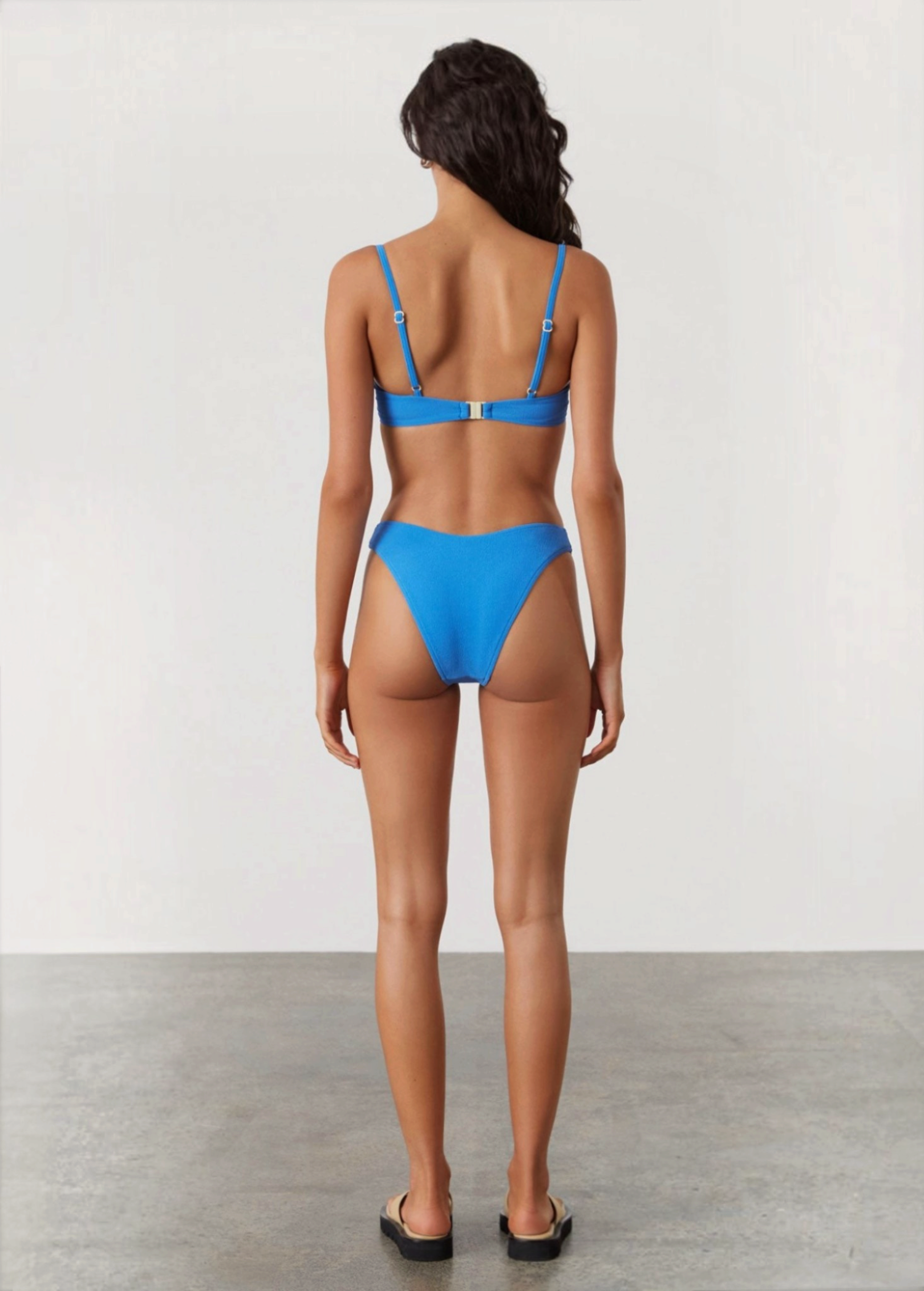 KABE SHOP INC ocean blue textured bikini brief with high-cut leg and curved waistline worn by a model from behind