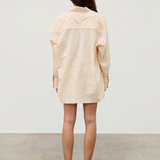 Back view of a person wearing a beige Shea Embroidered Hemp Blend Shirt with geometric floral embroidery on the back.