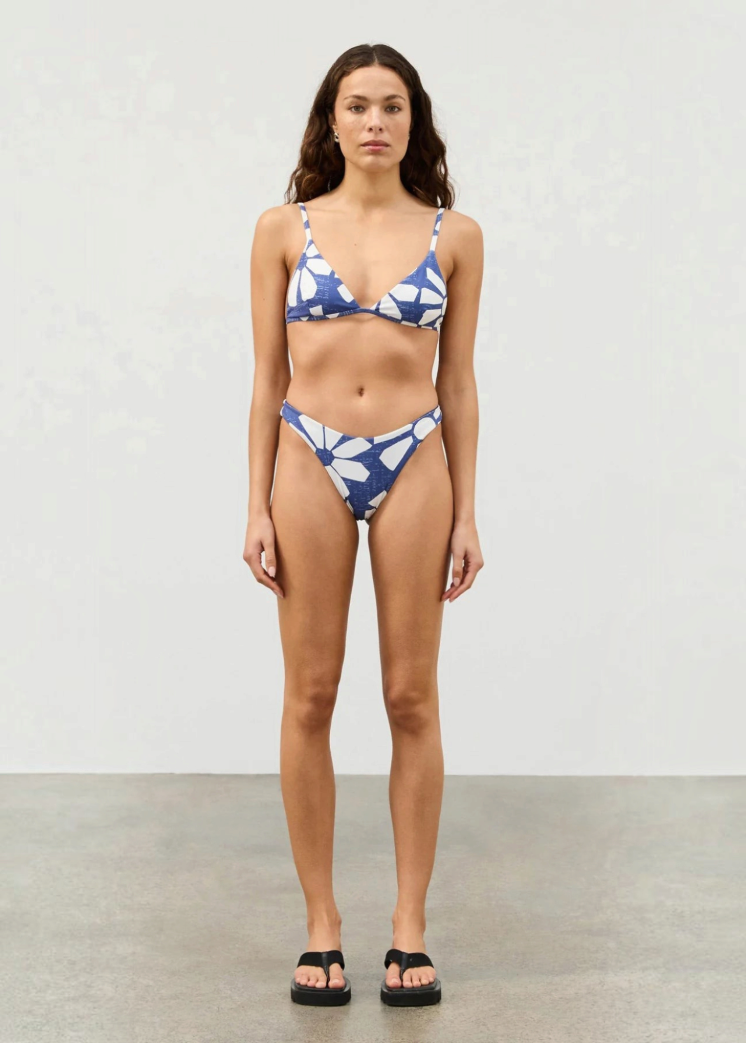 Model wearing KABE SHOP INC Geo Flower Curve Brief with high-cut legs and blue and white floral pattern