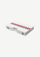 The ZigZag Backgammon Board Game features a closed white acrylic case adorned with colorful zigzag patterns and metal clasps, as well as a small handle slot centered at the front—making this striking set a standout on any coffee table.