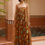 KABE SHOP INC strapless midi gown in brown with vibrant butterfly patterns, worn by a model in a tiled courtyard.