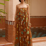 KABE SHOP INC strapless midi gown in brown with vibrant butterfly patterns, worn by a model in a tiled courtyard.