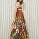 Model wearing a KABE SHOP INC Alfie Twist brown midi sundress with floral print and striped trim against striped wall
