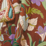 KABE SHOP INC Alfie Twist Sundress featuring a brown midi dress with a vibrant purple and green floral botanical print.