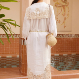 KABE SHOP INC Rosemary midi dress in white linen with intricate lace trim, worn with a straw hat and woven bag.