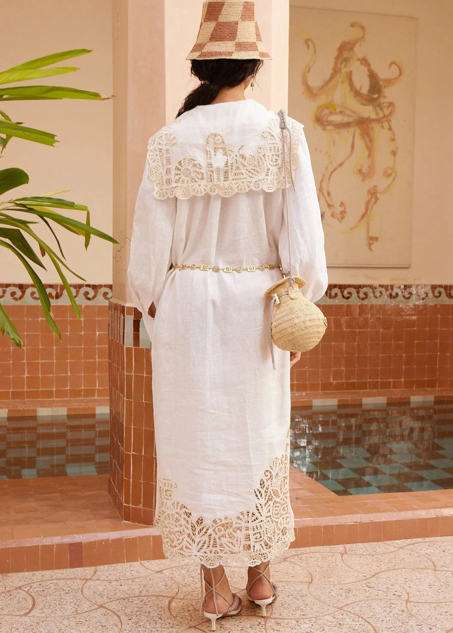 KABE SHOP INC Rosemary midi dress in white linen with intricate lace trim, worn with a straw hat and woven bag.