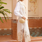 Model wearing KABE SHOP INC Rosemary midi dress in white linen with intricate lace hem and long sleeves