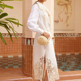 Model wearing KABE SHOP INC Rosemary midi dress in white linen with intricate lace hem and long sleeves