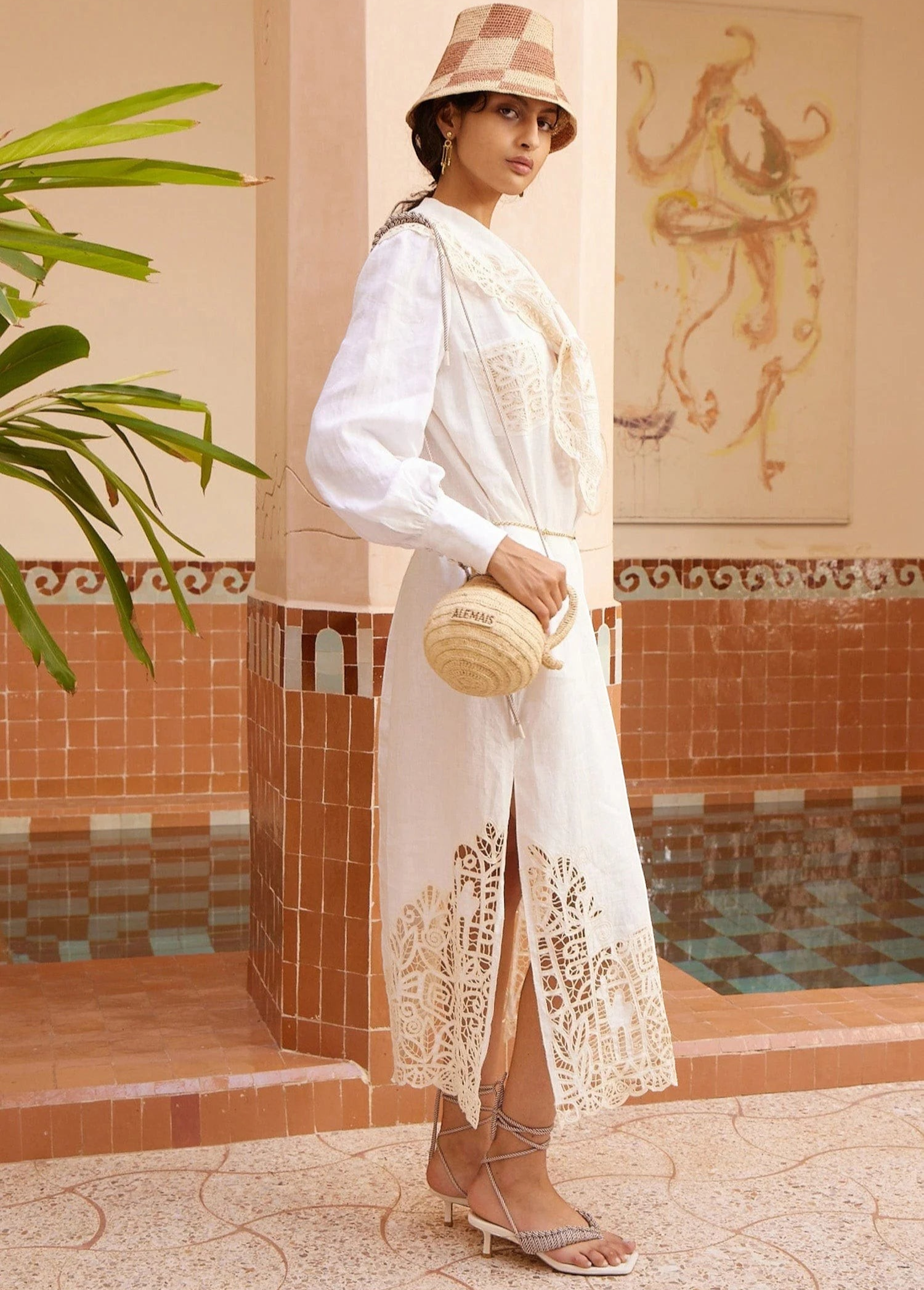 Model wearing KABE SHOP INC Rosemary midi dress in white linen with intricate lace hem and long sleeves