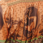 KABE SHOP INC Alberta shirtdress featuring a brown and orange tropical print with smocked detailing and green trim.