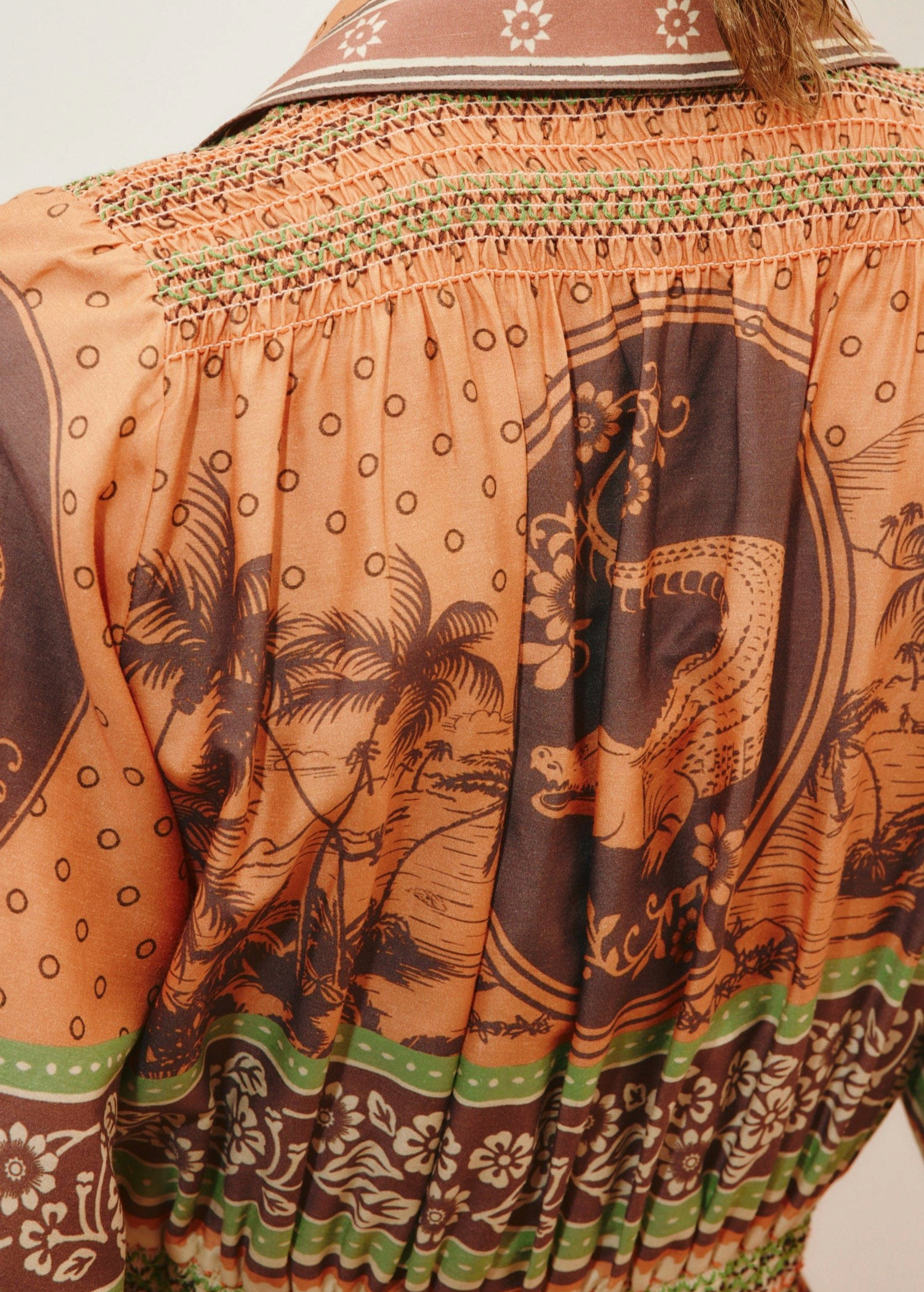 KABE SHOP INC Alberta shirtdress featuring a brown and orange tropical print with smocked detailing and green trim.