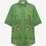 The green, relaxed fit Sun Dancer Shirt features a button-up front and an embroidered pattern of stars, moons, and abstract floral motifs.
