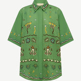 The green, relaxed fit Sun Dancer Shirt features a button-up front and an embroidered pattern of stars, moons, and abstract floral motifs.