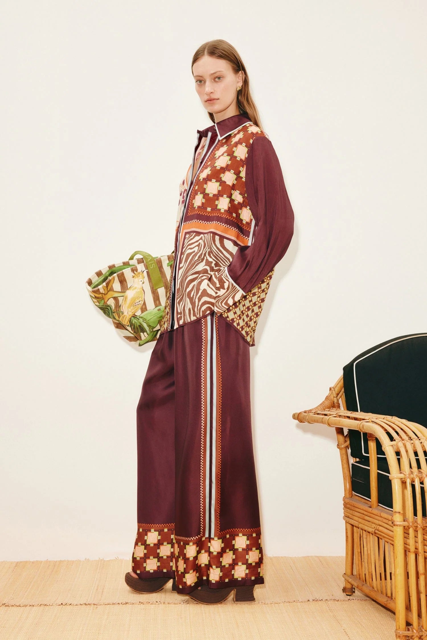 A person wears a Wilson Shirt and matching wide-leg trousers, both featuring a mix of geometric, checkered, and zebra print patterns in burgundy, brown, and cream to create a versatile silhouette.