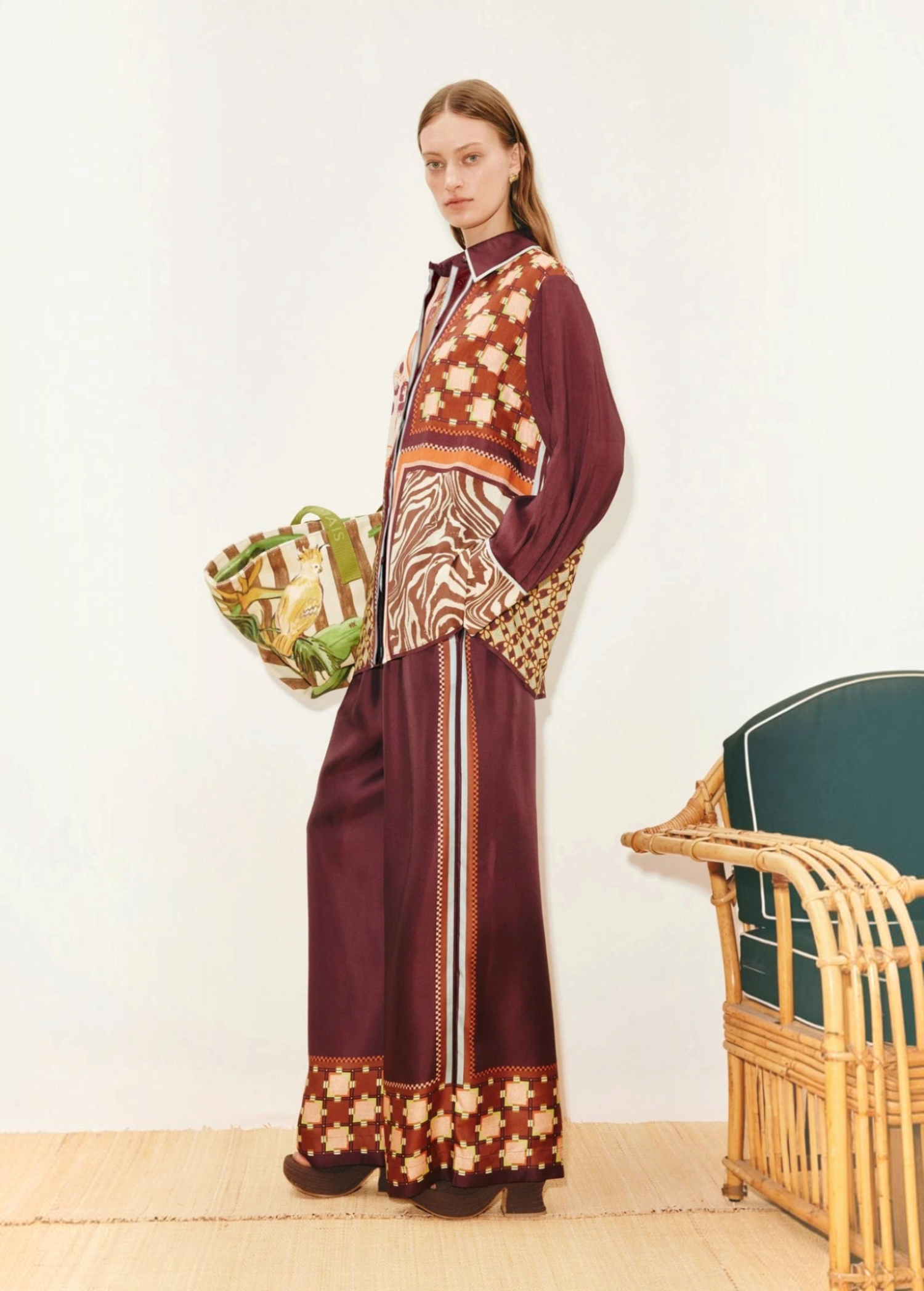 A person wears a Wilson Shirt and matching wide-leg trousers, both featuring a mix of geometric, checkered, and zebra print patterns in burgundy, brown, and cream to create a versatile silhouette.