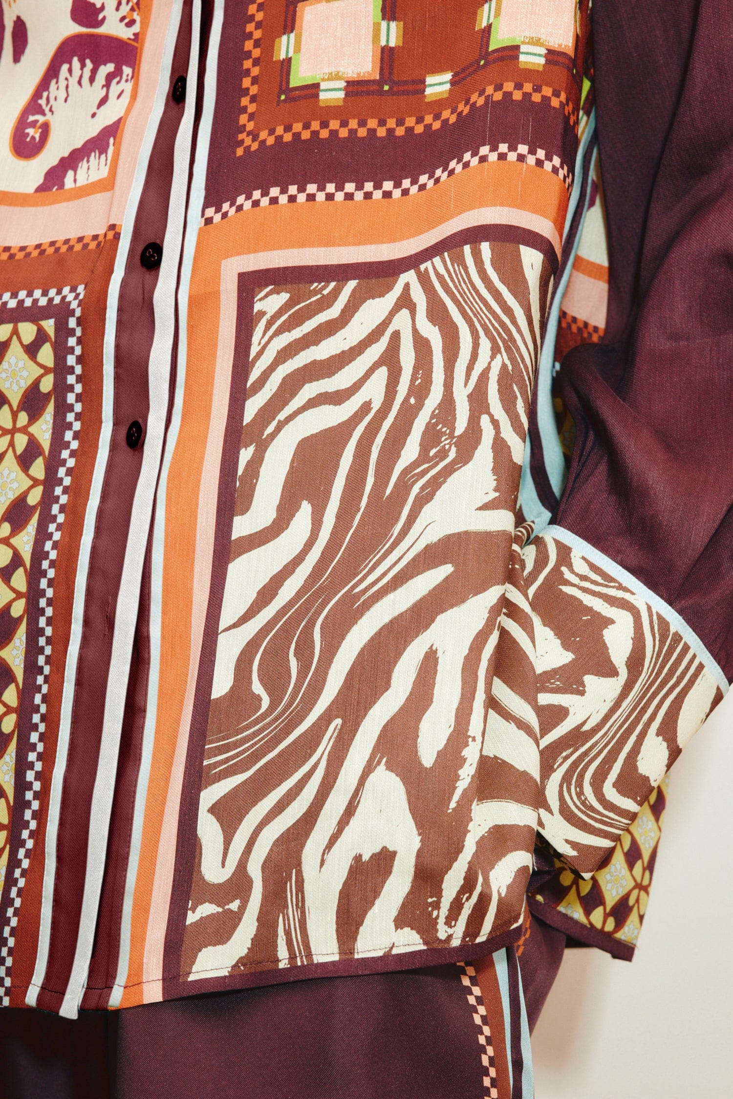 Close-up of the Wilson Shirt, a relaxed, button-down featuring a patchwork design of brown and white zebra print, geometric patterns, and solid dark panels.