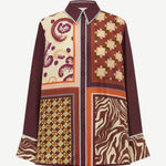 The Wilson Shirt is a versatile, relaxed-fit button-down featuring a patchwork of paisley, geometric, and zebra-print panels in shades of maroon, orange, and cream.