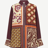 The Wilson Shirt is a versatile, relaxed-fit button-down featuring a patchwork of paisley, geometric, and zebra-print panels in shades of maroon, orange, and cream.