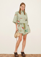 Model wearing KABE SHOP INC Bisou Short in green striped fabric with tropical print and a matching button-up shirt.