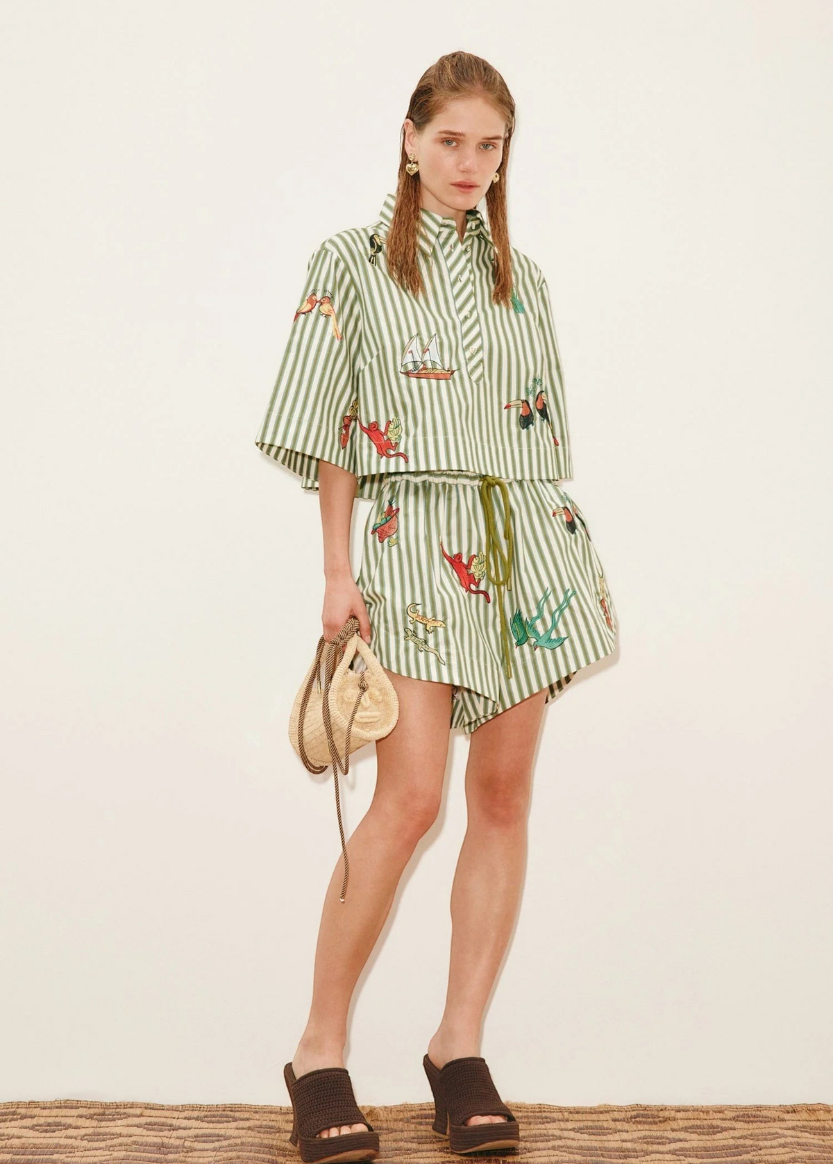 Model wearing KABE SHOP INC Bisou Short in green striped fabric with tropical print and a matching button-up shirt.