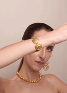 KABE SHOP INC Allinmi bracelet featuring gold spiral Tairona-inspired links worn on a model's wrist