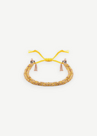 Introducing the N° 183 Braided Bracelet—an elegant piece crafted from yellow and rose gold threads, featuring two delicate dangling tassels and an adjustable closure. Its subtle yellow gold finish is beautifully showcased against a pristine white background.