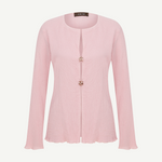 Light pink Malaika top with a textured finish, long sleeves, a round neckline, and two decorative jeweled buttons at the center closure.