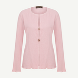 Light pink Malaika top with a textured finish, long sleeves, a round neckline, and two decorative jeweled buttons at the center closure.