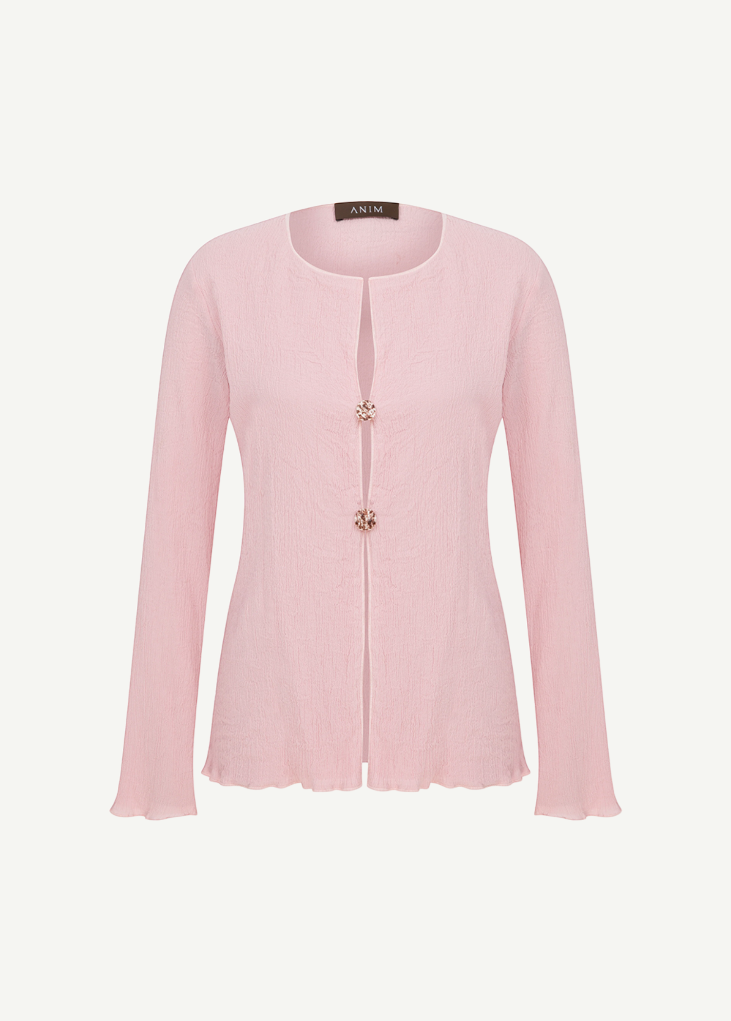 Light pink Malaika top with a textured finish, long sleeves, a round neckline, and two decorative jeweled buttons at the center closure.
