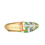 The Anzu Moccasin is a hand-embroidered shoe in green, orange, and cream with intricate patterns and “Meher Kakalia” inscribed on the insole, shown from above against a white background.