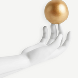 KABE SHOP INC Atlas porcelain incense holder featuring a white hand sculpture balancing a gold sphere on fingertips.