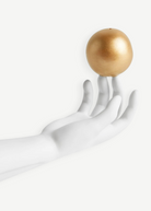 KABE SHOP INC Atlas porcelain incense holder featuring a white hand sculpture balancing a gold sphere on fingertips.