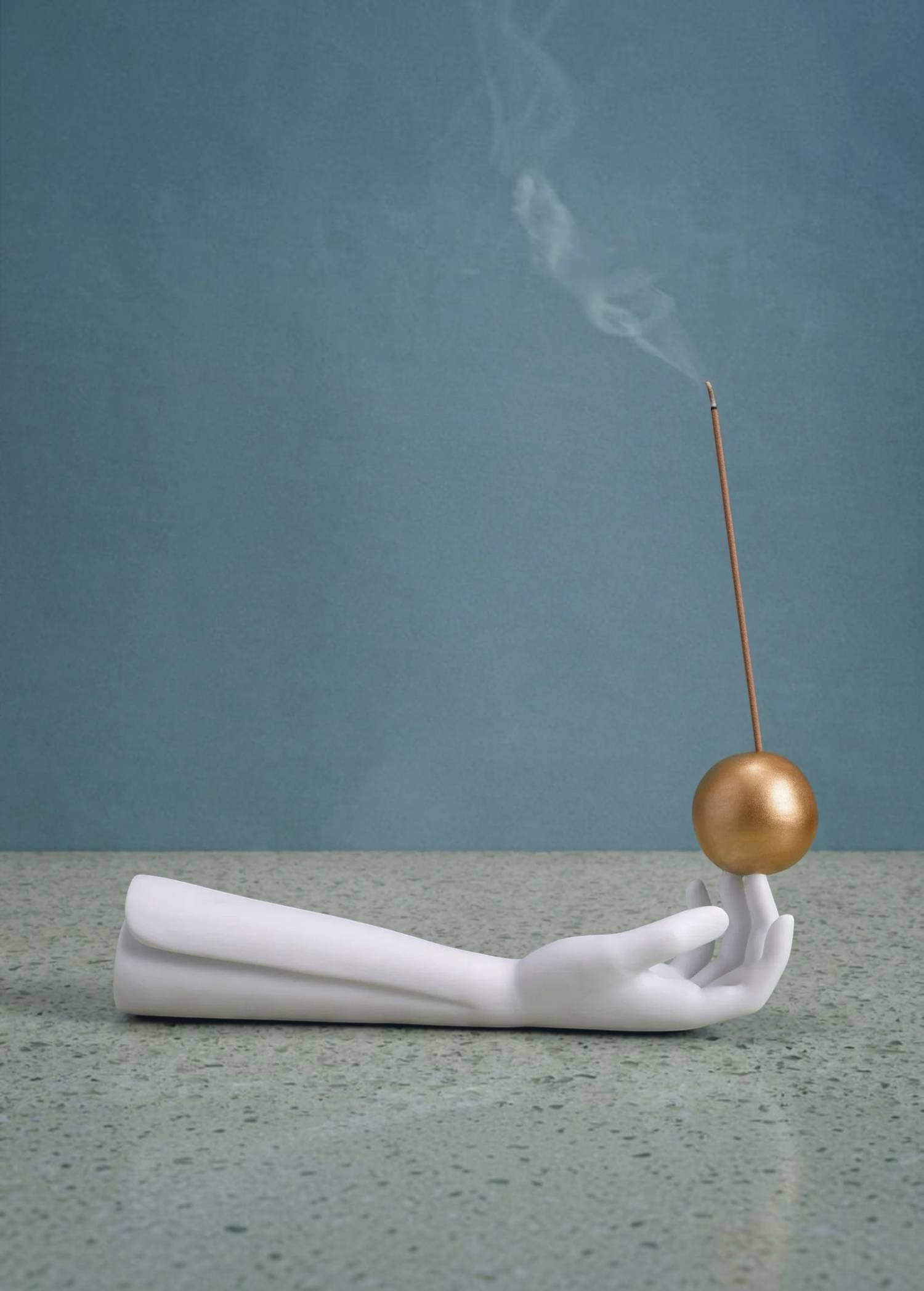 KABE SHOP INC Atlas porcelain incense holder featuring a white hand sculpture balancing a gold sphere with incense