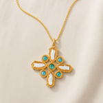 KABE SHOP INC Croix Baroque pendant necklace featuring a gold cross with white baroque pearls and turquoise stones.