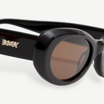 KABE SHOP INC Naomi sunglasses featuring a black oval cellulose acetate frame and brown lenses with gold logo detail